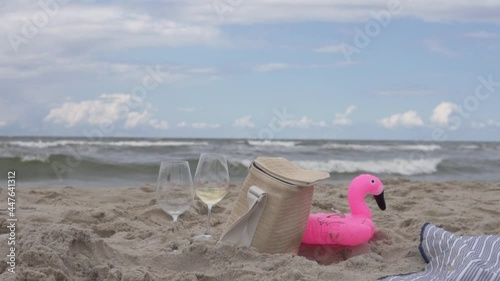 Two glasses of wine against the background of oxen in the sea and cloudy sky on the beach.