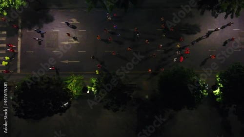 Aerial top shot of many runners running on the street at night of Ho Chi Minh City, Vietnam photo