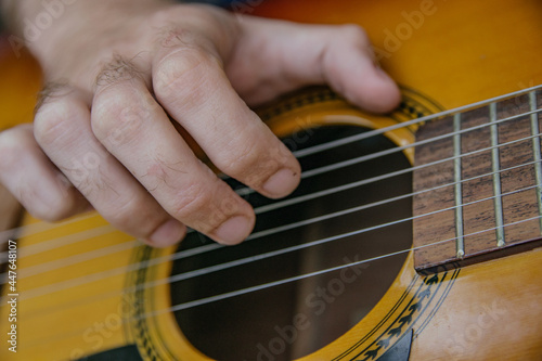 close-up of a guitar playing with a man's hand playing the strings