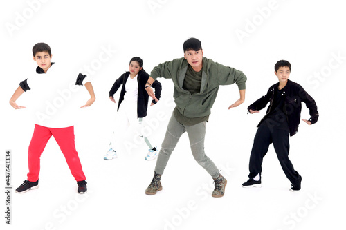 Group of happy kids studying modern style dance in indoor studio classroom with their teacher, children and adult dancing white background.