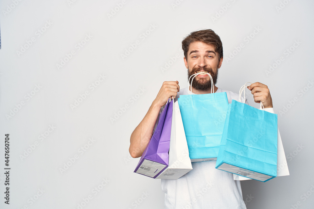 a man in a white t-shirt with packages in his hands discounts Shopping emotions a man in a white t-shirt with packages in his hands discounts Shopping emotions