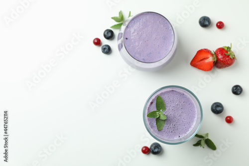 Glasses of smoothie and ingredients on white background