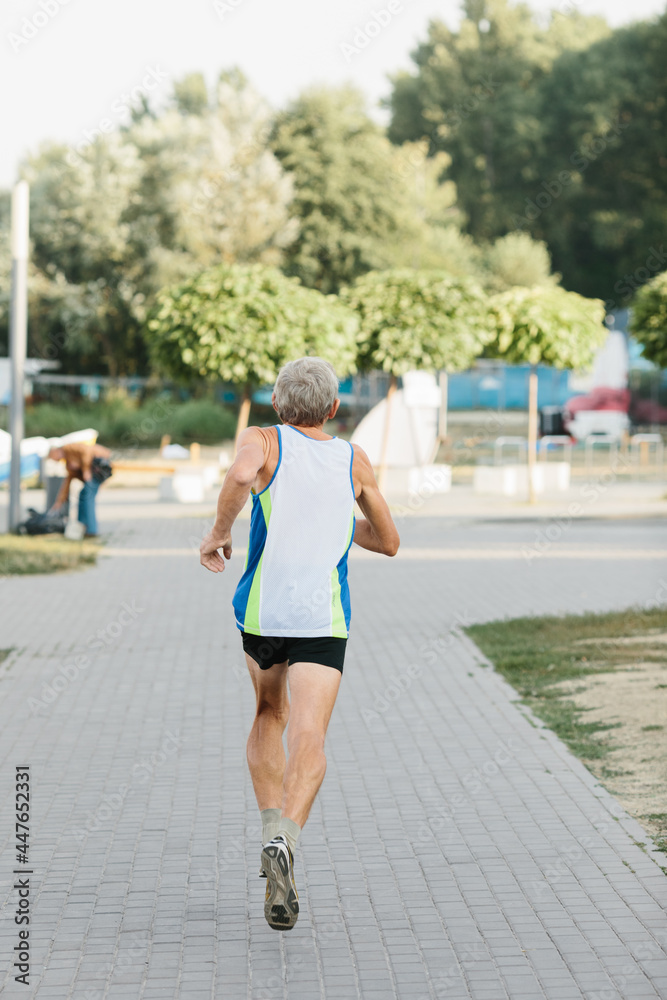older man is engaged in running in the fresh air