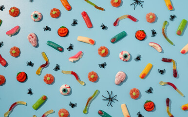 Colorful sweets for Halloween party on blue background, top view