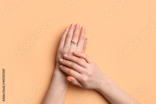 Hands with beautiful manicure and ring on color background