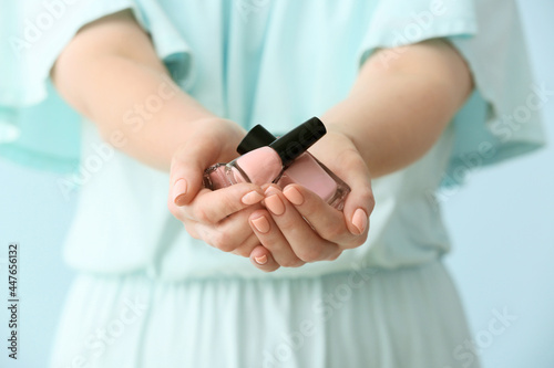 Woman with beautiful manicure and nail polish on color background, closeup