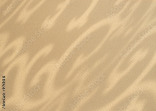 Abstract ornamental shadow on beige, sandy colour paper background. Irregular ethnic pattern.