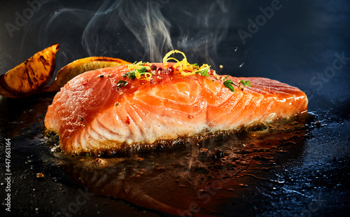 Gourmet portion of thick juicy salmon grilling on a griddle