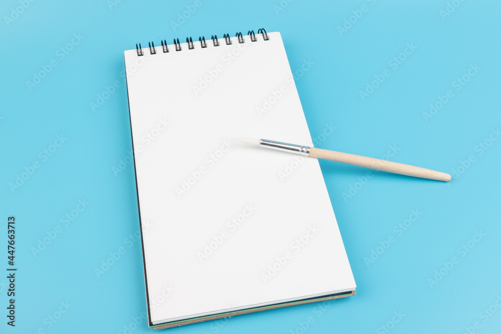 White clean sketchbook, brush and with copy space. Artist workspace concept. High-quality photo White clean sketchbook, brush and with copy space. Artist workspace concept. High-quality photo