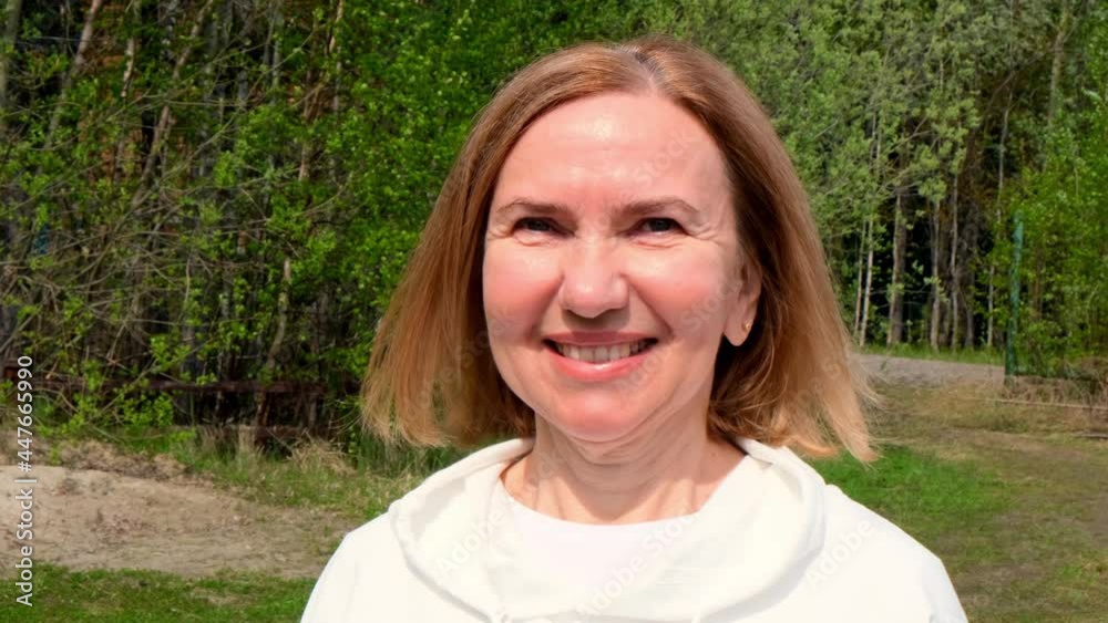 charismatic Beautiful mature woman face. Mid adult lady smiling outdoors. Portrait of female age 55-60 relaxing in garden. charismatic Beautiful mature woman face. Mid adult lady smiling outdoors. Portrait of female age 55-60 relaxing in garden.
