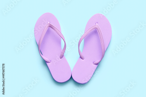 Stylish flip-flops on color background