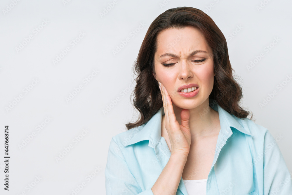 Young Woman Suffering From Strong Teeth Pain, Touching Cheek With Hand. Dentistry Concept Young Woman Suffering From Strong Teeth Pain, Touching Cheek With Hand. Dentistry Concept