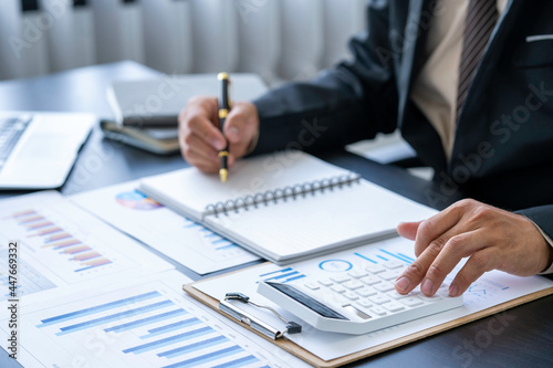 businessman working on the desk with using calculator and computer in the office. concept accounting finance and invest