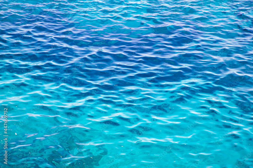 blue colored clear water surface texture with ripples, splashes and bubbles