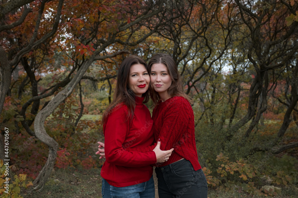 Fototapeta premium Mature mother hugging with her teen daughter outdoor in nature