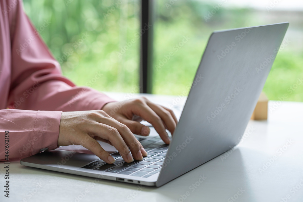 Businesswoman using laptop and analyzing financial data at office desk. Businesswoman using laptop and analyzing financial data at office desk.