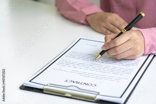 Real estate agent holding home and signing contract about agreement of real property on desk, businessman writing on document form rent house, house broker and planning investment, business concept