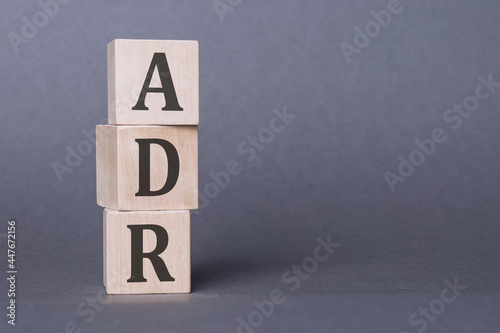 ADR - Adverse Drug Reaction, text written on wooden blocks over gray background. photo