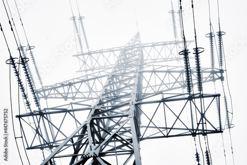 A high-voltage electricity pylons against clear sky and fog