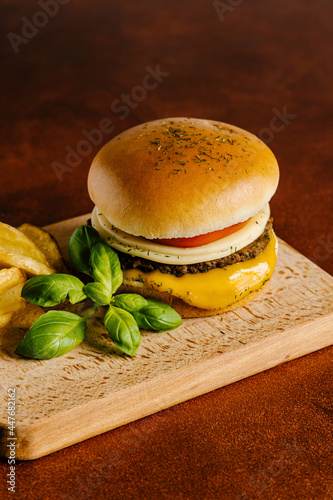 Cheese and beef burger with mustard barbecue sauce and french fries photo