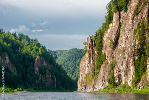 Landscape of Siberia. Kiya River, mountain banks and green forests in the Kemerovo region. Daytime landscape with blue skies and clouds. photo