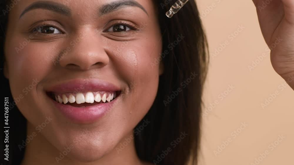 African American Lady Applying Facial Serum Posing Over Beige Background African American Lady Applying Facial Serum Posing Over Beige Background