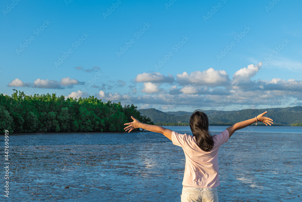 The woman stood with her arms outstretched as she felt free to go out to sea on vacation. The woman stood with her arms outstretched as she felt free to go out to sea on vacation.