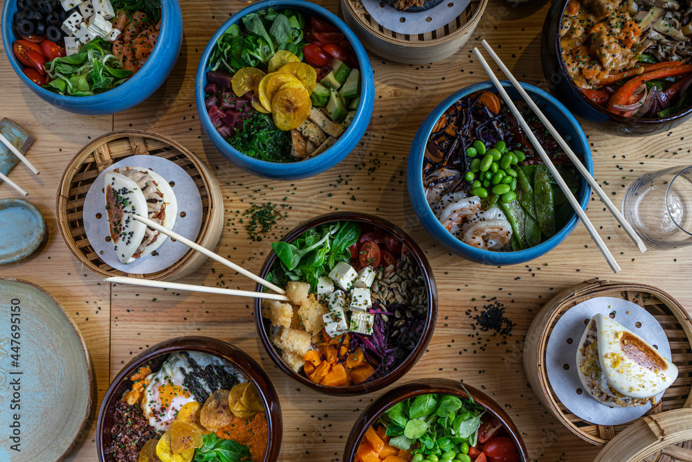 Top view of a few bowls of poke in colorful bowls Top view of a few bowls of poke in colorful bowls