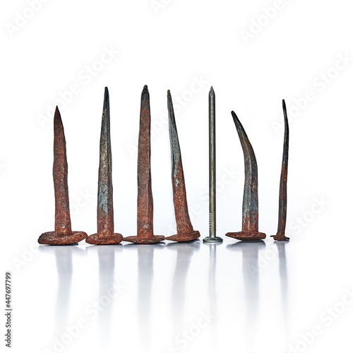 Row of rusty old nails of different heights arranged as graph on white background.
