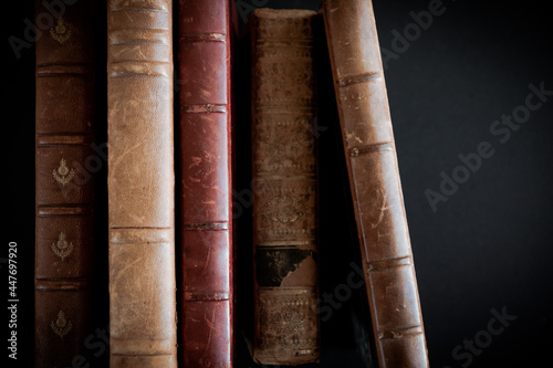 Row of old books on black background