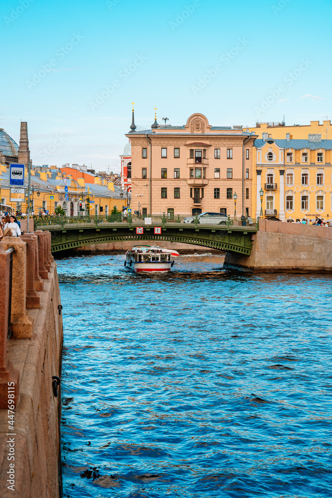 Beautiful view of the Neva river canal in the city center with tourist excursion boats, postcard view. Saint Petersburg, Russia - 11 June 2021