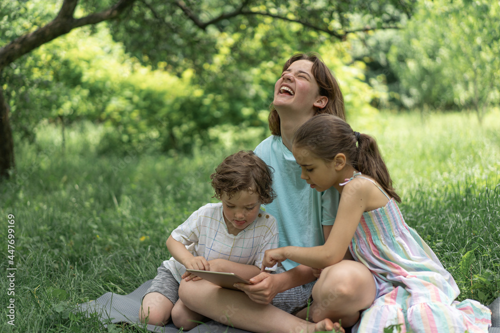 Children with a tablet outdoors. Children play games on the tablet. Technology concept. Children with a tablet outdoors. Children play games on the tablet. Technology concept.