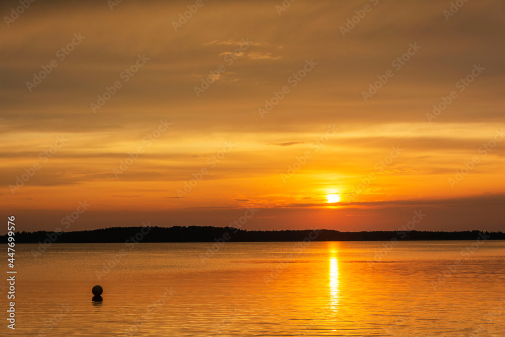 a fascinating sunset on a forest lake in a quiet summer evening, a journey, a water surface