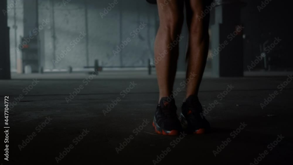 Athlete legs jumping on skipping rope in gym. Man feet doing cardio workout Athlete legs jumping on skipping rope in gym. Man feet doing cardio workout