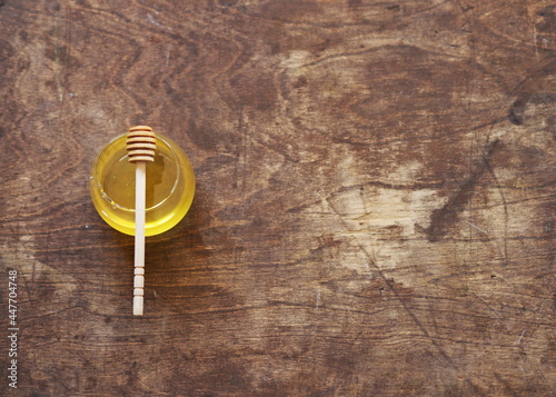 Natural products concept. On a natural wooden background honey and a spoon with honey.