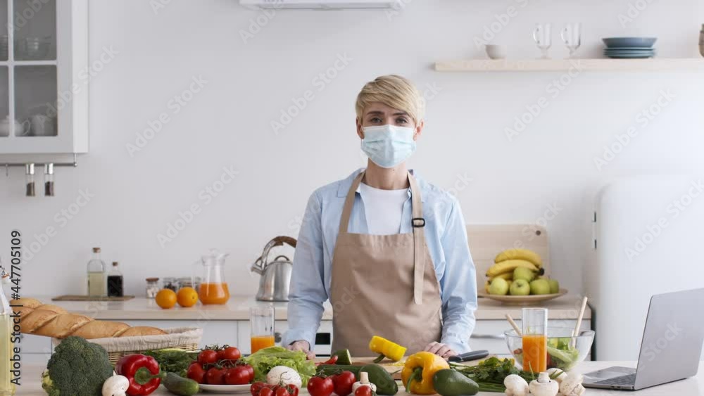 Middle-Aged Lady Wearing Face Mask Standing In Kitchen At Home Middle-Aged Lady Wearing Face Mask Standing In Kitchen At Home