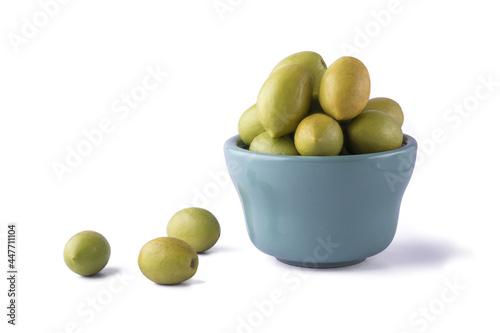 ceylon olives or wild olives, smooth oval shaped tropical fruit in a cup isolated on white background