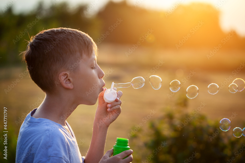 Child blowing soap bubbles on a summer day at sunset nature. Child blowing soap bubbles on a summer day at sunset nature.