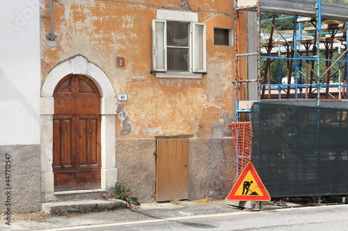 Central Italy Village Street View with Old House Facade,  Construction Site and Road Sign photo