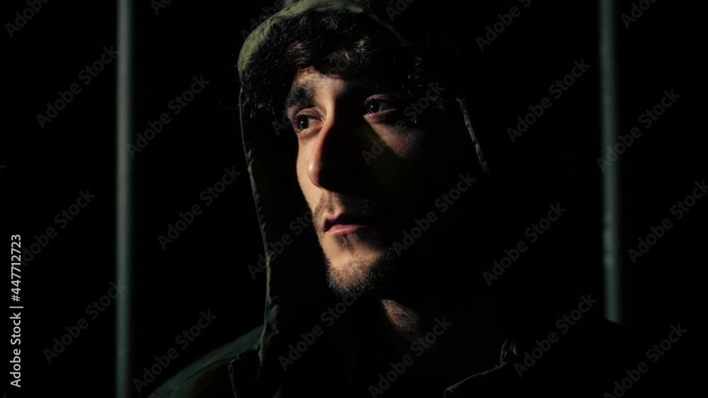 crime, guilt - young hooded man looks menacingly at the camera - night scene crime, guilt - young hooded man looks menacingly at the camera - night scene