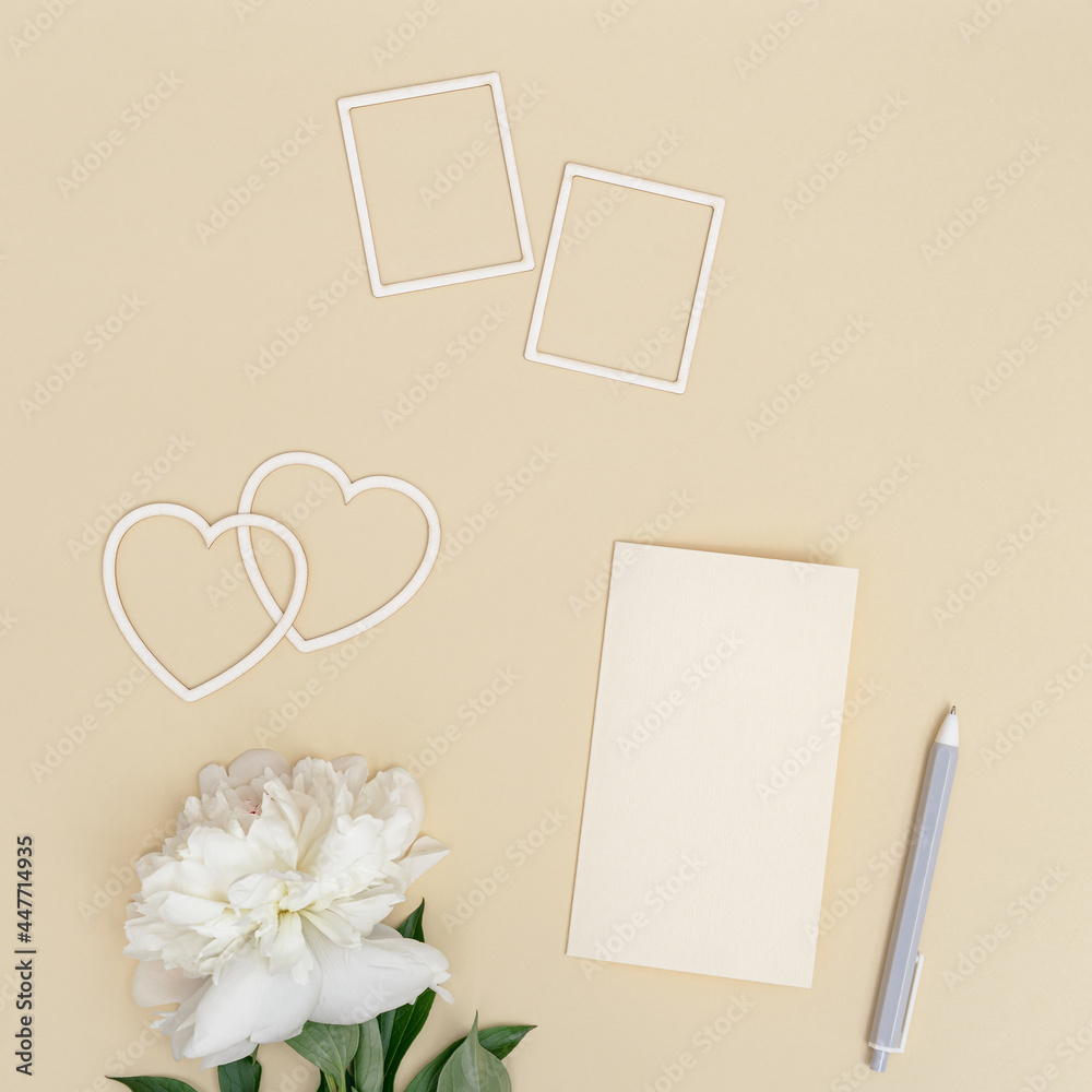 Romantic holiday or Valentines Day flat lay with fresh white peony flower, postcards for celebration wishes, pen, hearts from paper Romantic holiday or Valentines Day flat lay with fresh white peony flower, postcards for celebration wishes, pen, hearts from paper