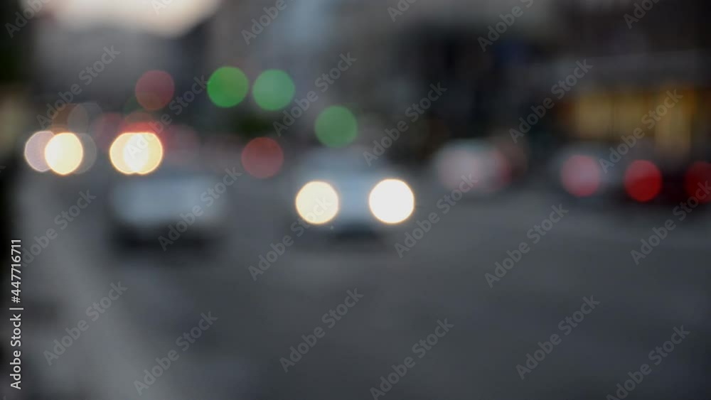 Defocused receding city traffic in the evening. Out of focus lights of traffic jam on city street. City blur background. Moving bokeh circles of evening traffic. Defocused receding city traffic in the evening. Out of focus lights of traffic jam on city street. City blur background. Moving bokeh circles of evening traffic.