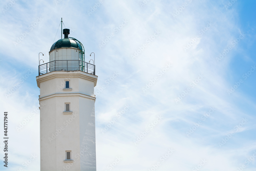 Lighthouse on the background of a sunny sky with clouds. Selective focus. Copy space.