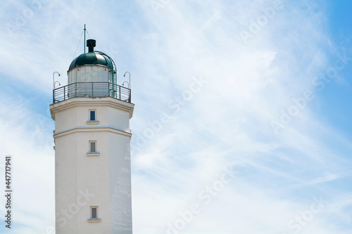 Lighthouse on the background of a sunny sky with clouds. Selective focus. Copy space.