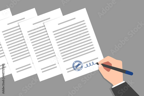 Stack of documents and hand of person signing them