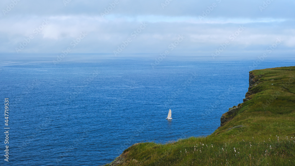 Catamaran sailing off the cliffs of Handa Island in the Highlands of Scotland