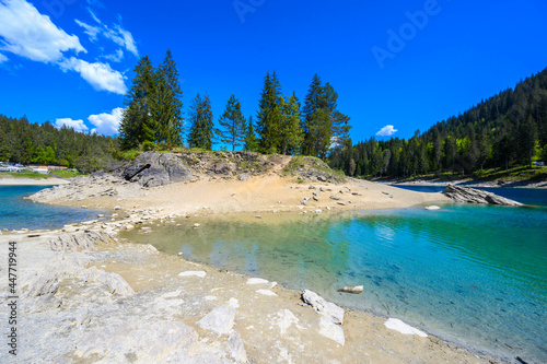 Small island in the middle of Cauma Lake (Caumasee) with crystal blue water in beautiful mountain landscape scenery at Flims, Graubuenden - Switzerland