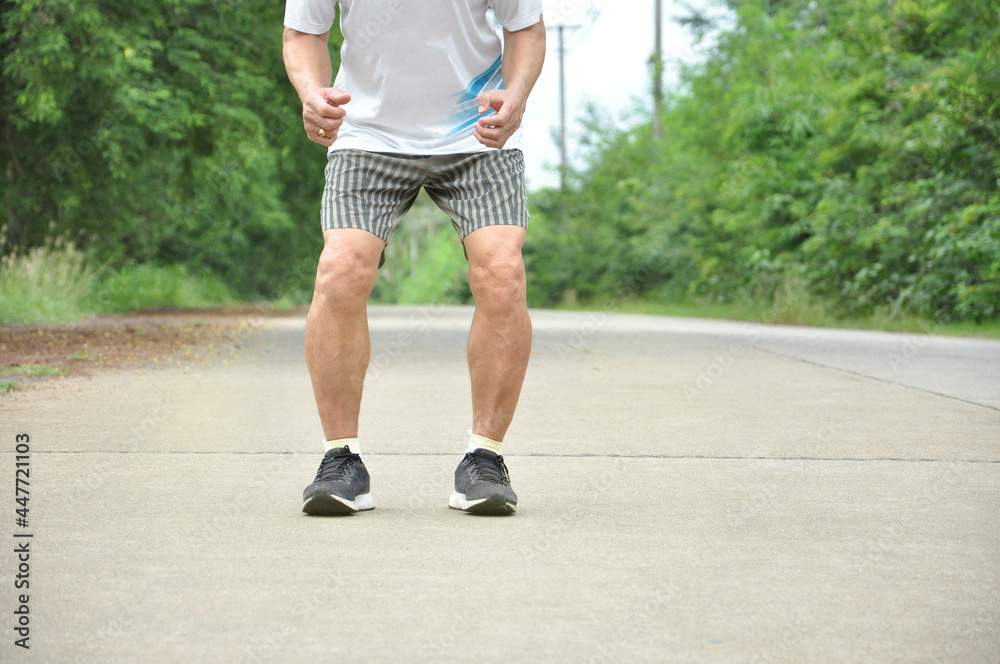 an old man with legs muscle while stretching his legs before exercise, concept health care in elderly people