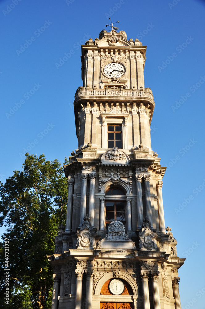 Old stone clock tower. Tower against a blue cloudless sky.