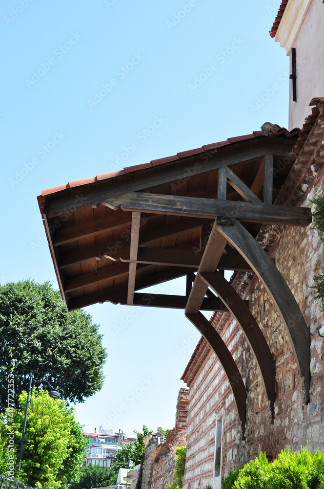 Wooden canopy over the entrance to the old stone house. Architectural element of the house.